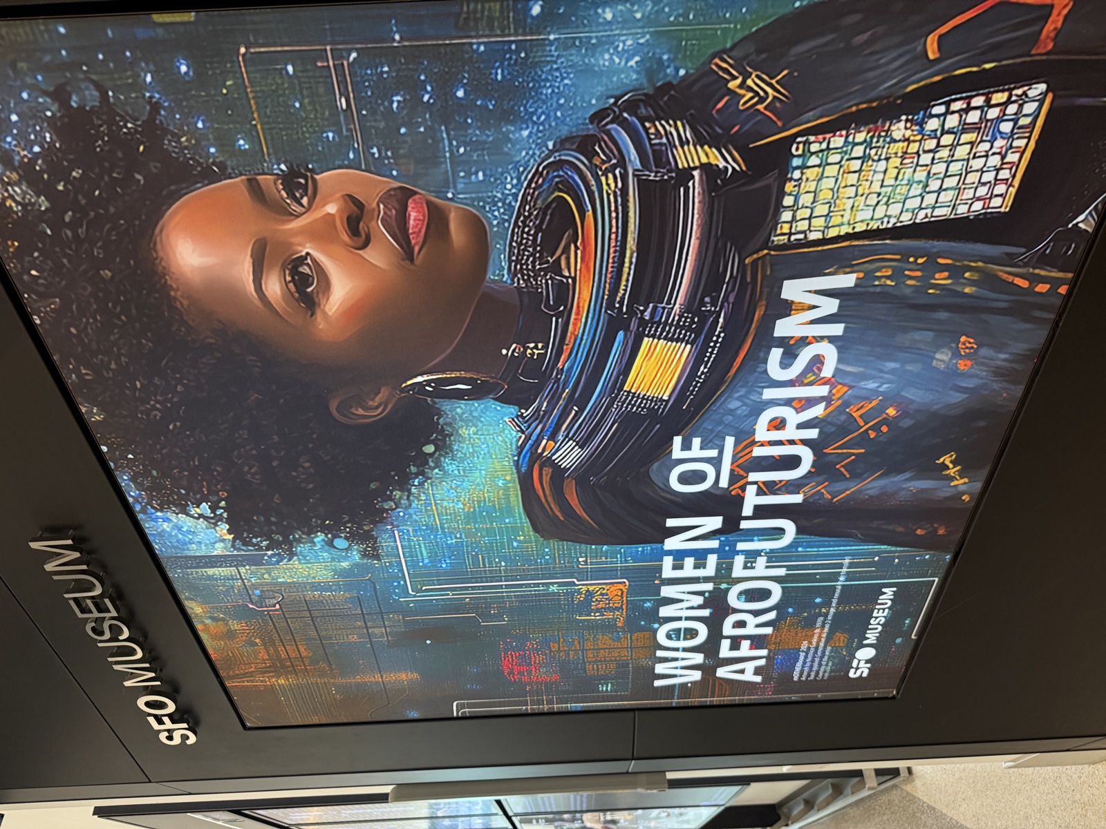 The SFO Museum exhibit sign for Women of Afrofuturism, featuring a portrait of a woman in Afrofuturist attire