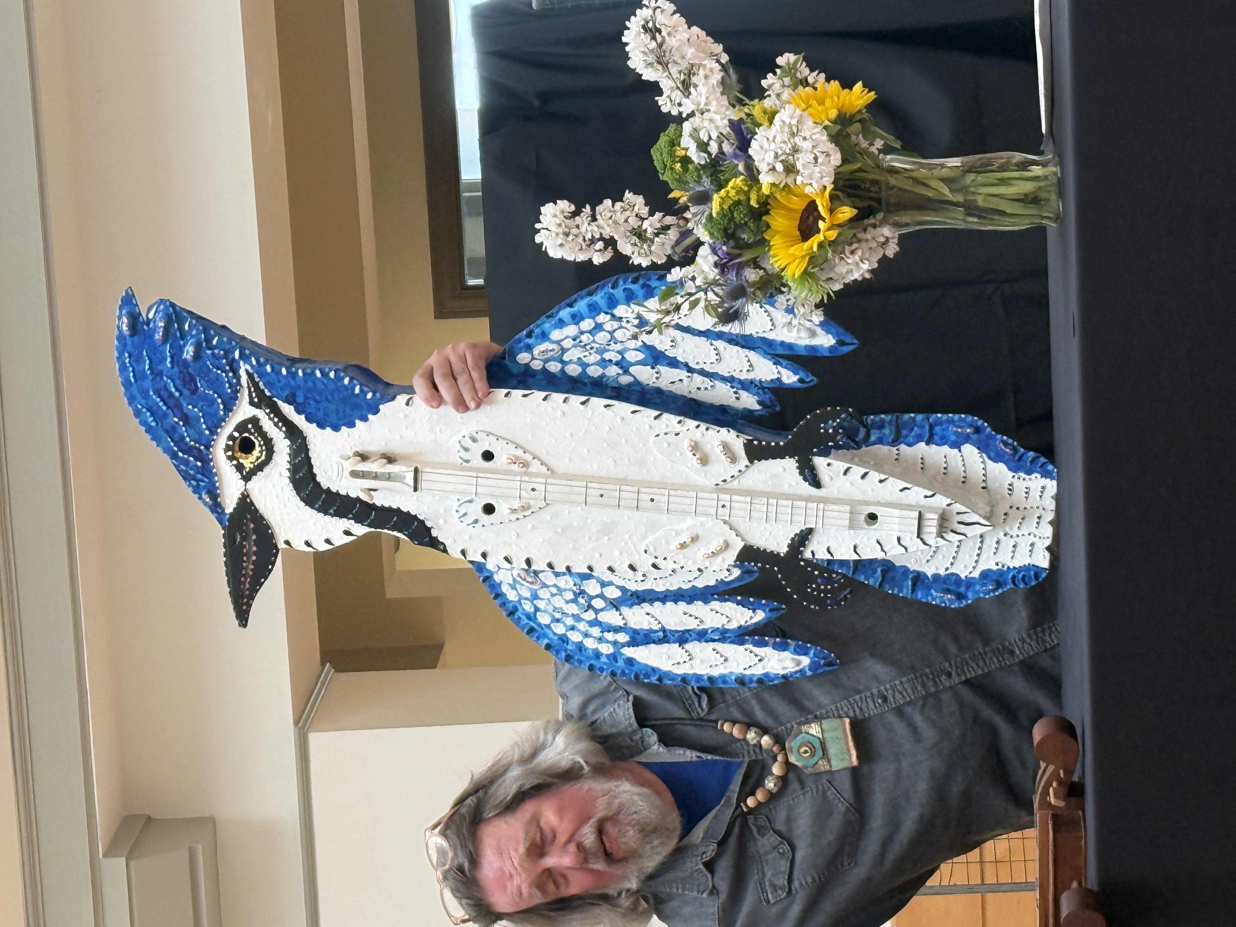 Peter Loose holds up his blue jay dulcimer at the Lyndon House Arts Center presentation. The instrument is nearly as tall as he is.